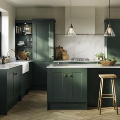 a kitchen with green cabinets and wooden stools next to the counter top, along with two hanging lights over the sink