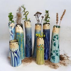 seven ceramic vases with plants in them