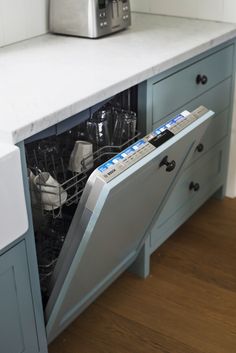 an open dishwasher sitting on top of a counter