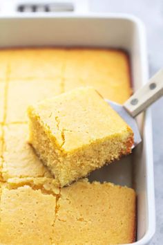 a pan filled with cornbread next to a spatula