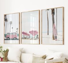 three framed pictures hang on the wall above a couch in a room with white furniture