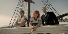 three people on a boat posing for a photo