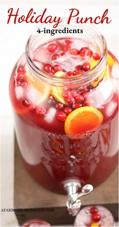 a glass jar filled with pomegranate and orange slices