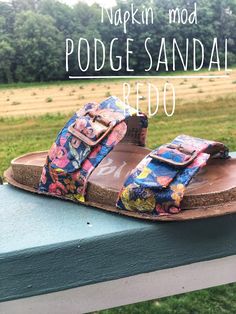 a pair of colorful sandals sitting on top of a wooden bench next to a field