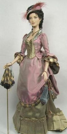 a statue of a woman wearing a pink dress and hat with a cane in her hand