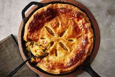 a pie sitting on top of a pan covered in cheese and toppings next to a napkin