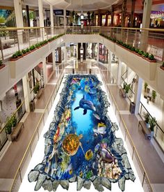 the floor is decorated with fish and marine life in this shopping mall, as well as several balconies