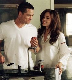 a man and woman standing in front of a sink