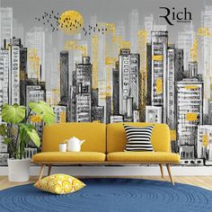 a living room with yellow couch and cityscape on the wall behind it, in front of a blue rug