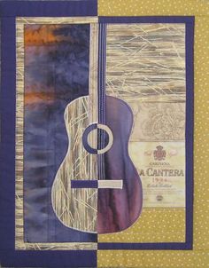 a quilted wall hanging with a guitar and wine bottle on it's side