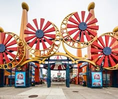 a person riding a bike in front of an amusement park ride area with ferris wheels