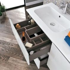 a bathroom sink sitting under a mirror next to a counter top with various items in it