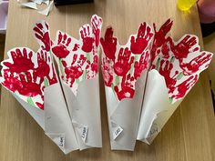 paper flowers with hand prints on them sitting on a table