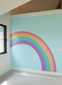 an empty room with a rainbow painted on the wall