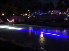 the pool is lit up with christmas lights