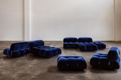 a group of blue chairs sitting on top of a cement floor