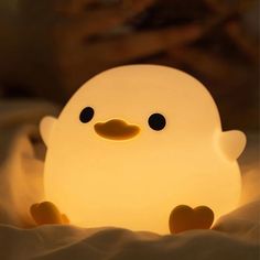 a white light that is shaped like a duck with black eyes and an orange nose