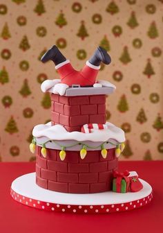 a cake made to look like a brick tower with santa's feet on top