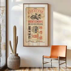 an old poster hangs on the wall next to a chair and cacti in a room