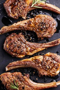 two steaks on a black platter with rosemary sprigs