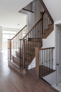 a white staircase with wooden handrails and hardwood floors in an empty house or apartment