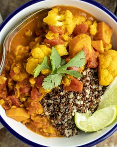 a bowl filled with lots of food and garnished in cilantro sauce