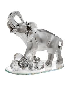 an elephant figurine on a glass base with crystal balls in the foreground