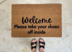 someone standing in front of a welcome mat that says, welcome please take your shoes off inside