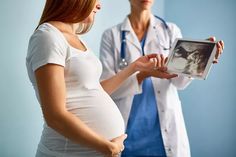 a pregnant woman holding an x - ray in front of a doctor's stethoscope