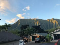 the mountains are in the distance with cars parked on the driveway and two garages