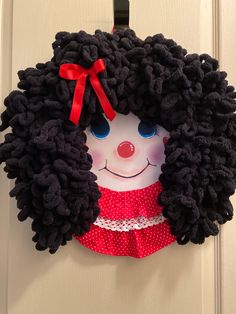 a door hanger with a black afro wig and red polka dot dress on it