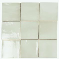 a white tile wall with square tiles on it