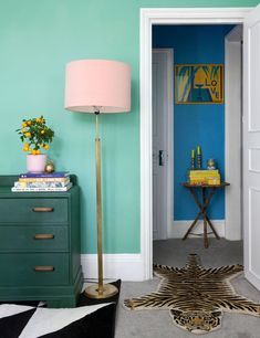 a living room with blue walls and a zebra print rug on the floor next to a green dresser