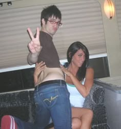 a man standing next to a woman on top of a couch