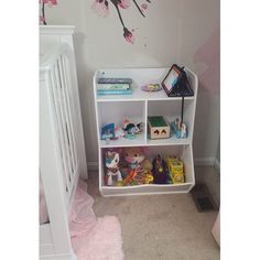 a baby's room with a white crib and pink flowers painted on the wall