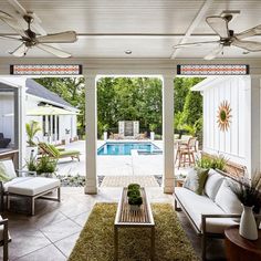 an outdoor living area with couches, tables and a pool in the back yard