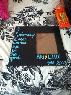 a black and white photo frame with writing on it sitting on top of a bed