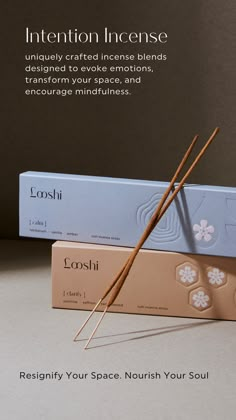 two incense sticks sitting next to each other in front of a box that says intention incense