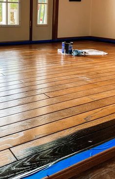 a room with hard wood flooring and blue tape on the floor next to it