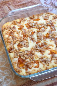 a casserole dish with meat and cheese in it sitting on a tablecloth