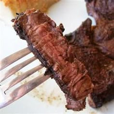 a fork is stuck into some meat on a plate