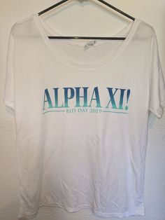 a white shirt that says,'alpha xi bid day 2019'on it