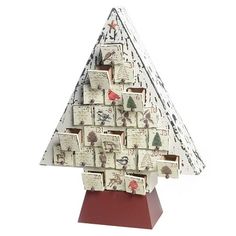 a christmas tree made out of small cards on a red stand with white and black designs