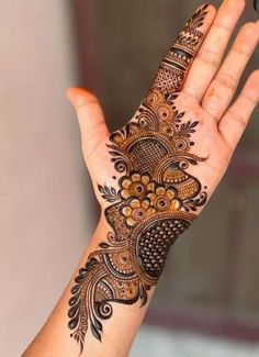 a woman's hand with henna tattoos on it