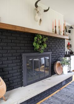 a living room with a black brick fireplace and shelves on the wall, decorated with deer heads