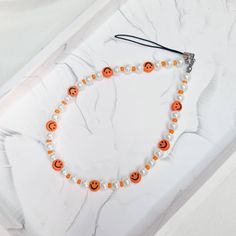 an orange and white beaded necklace with jack - o'- lanterns on it