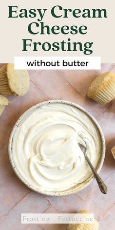 an easy cream cheese frosting in a bowl with a spoon and muffins on the side