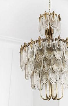 a chandelier hanging from the ceiling in a room with white walls and flooring