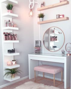 a white desk with a mirror and shelves on the wall above it, along with a pink stool