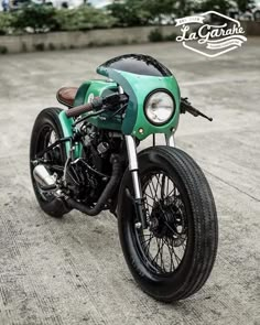 a green motorcycle parked on top of a parking lot